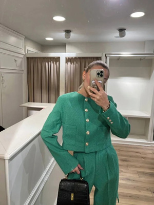 Yeşil kadın ceket modeli bulunur elinde telefon bulunan kadının üzerinde.