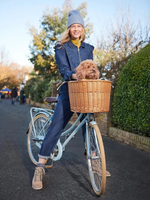 Lacivert kadın tulum modeli bulunur sepetinde köpek olan bisiklete binmiş kadının üzerinde.